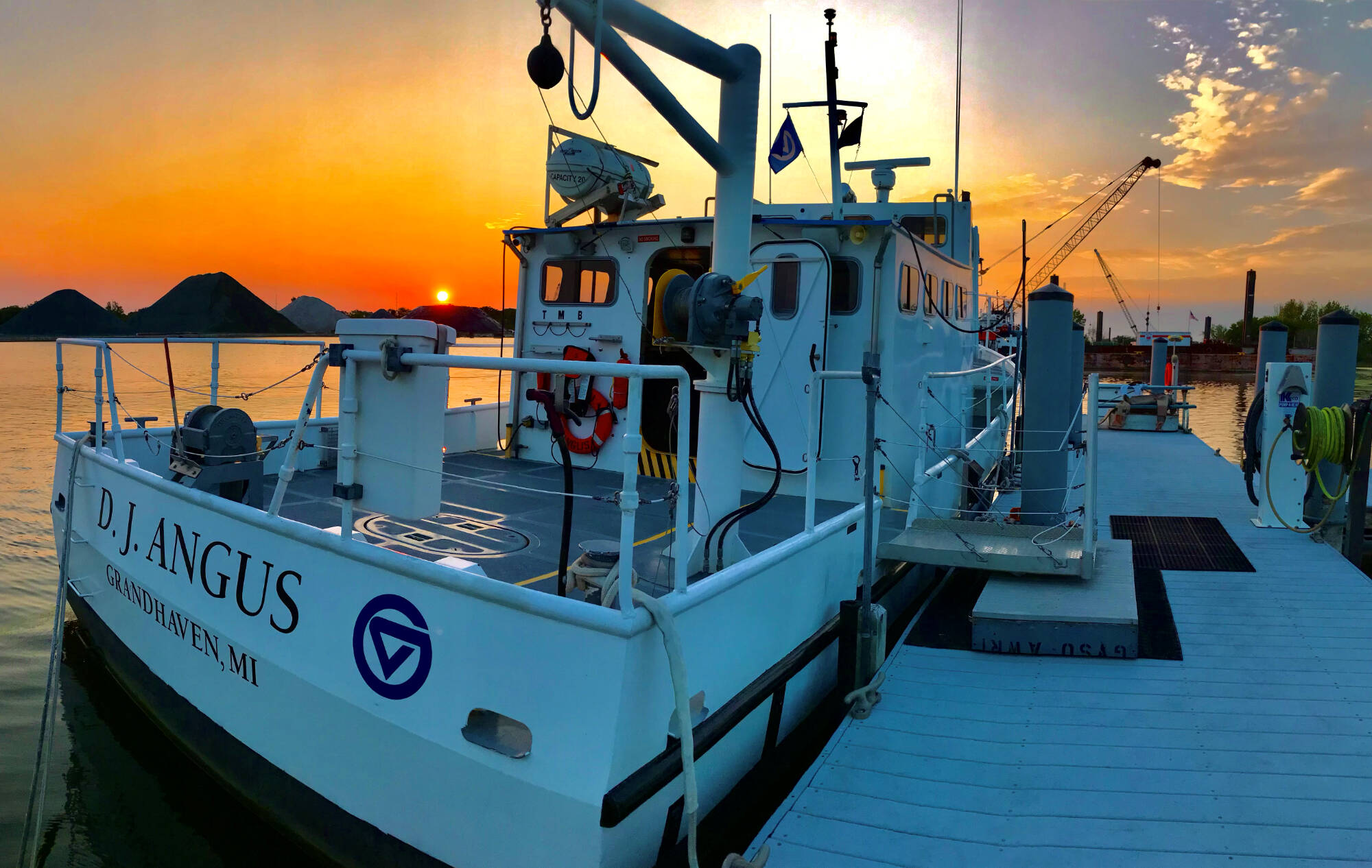 Sunrise creates an orange sky behind the D.J. Angus at its dock in Grand Haven, MI.